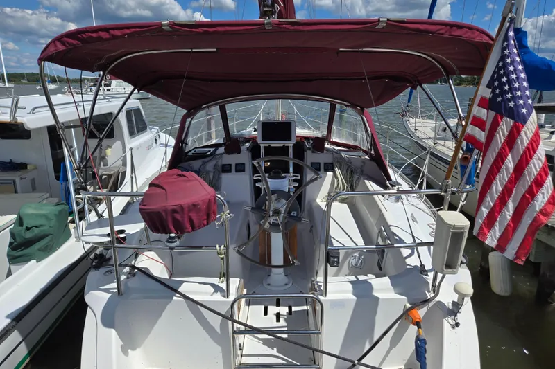 Slide: The Image of Sailboat with maroon canopy, American flag, docked; Hunter 35.5, 1992 model. - 2