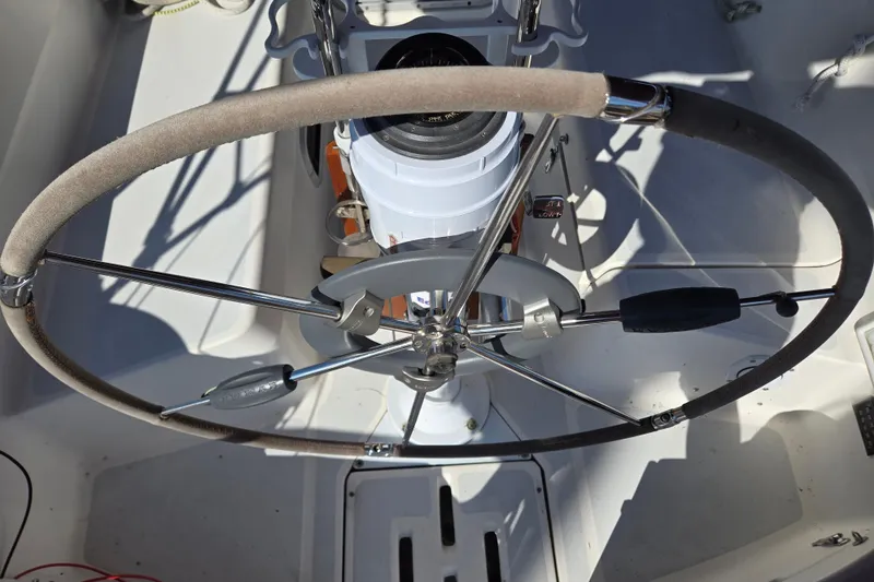 Slide: The Image of Steering wheel of a 1992 Hunter 35.5 sailboat, featuring a compass and control panel. - 23