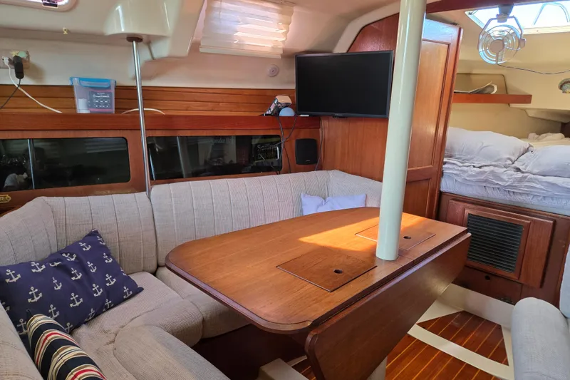Slide: The Image of Cozy interior of a 1992 Hunter 35.5 sailboat with a dining area and sleeping quarters. - 4