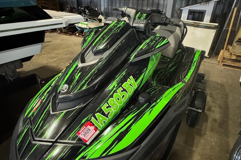 The Image of 2021 Yamaha WaveRunner FX SHO with vibrant green and black design in storage. - 1