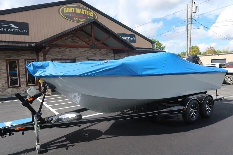 Slide: The Image of 2008 Starcraft STX PRO 2050 boat with blue cover on trailer outside dealership. - 11