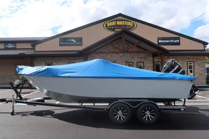 Slide: The Image of 2008 Starcraft STX PRO 2050 boat with blue cover on trailer, parked outside dealership. - 12