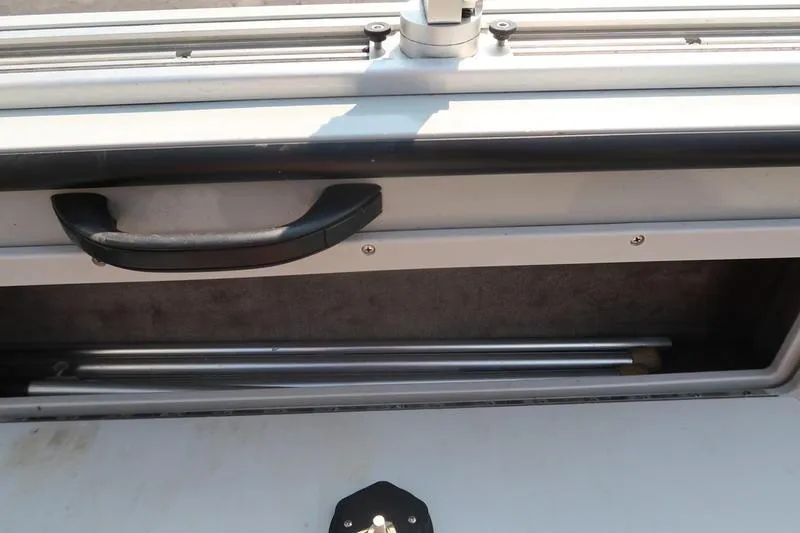 Slide: The Image of Storage compartment of a 2008 Starcraft STX PRO 2050 boat, featuring a handle and metal rods. - 23