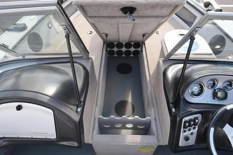 Slide: The Image of 2008 Starcraft STX PRO 2050 boat interior with open storage compartment and dashboard controls. - 68