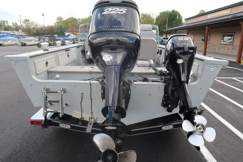 Slide: The Image of 2008 Starcraft STX PRO 2050 boat with dual outboard motors in a parking lot. - 9