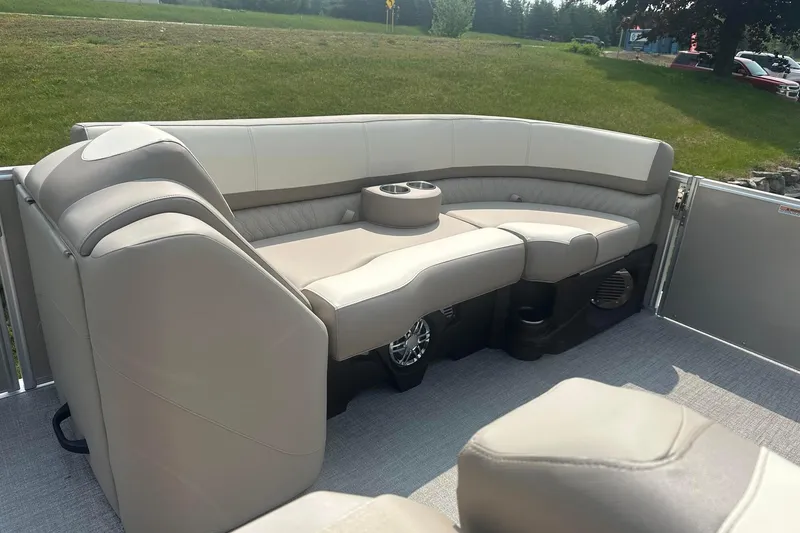 Slide: The Image of 2025 Tahoe 2585 boat interior with beige seating and cup holder on a sunny day. - 14