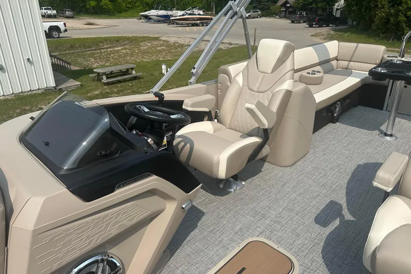 Slide: The Image of 2025 Tahoe 2585 boat interior with beige seating and modern helm design. - 16
