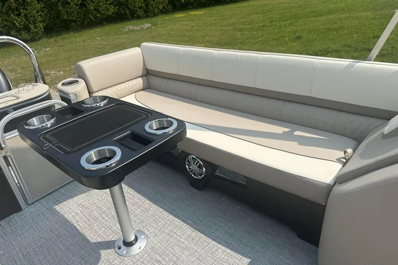 Slide: The Image of 2025 Tahoe 2585 boat interior with beige seating and a table featuring cup holders. - 17