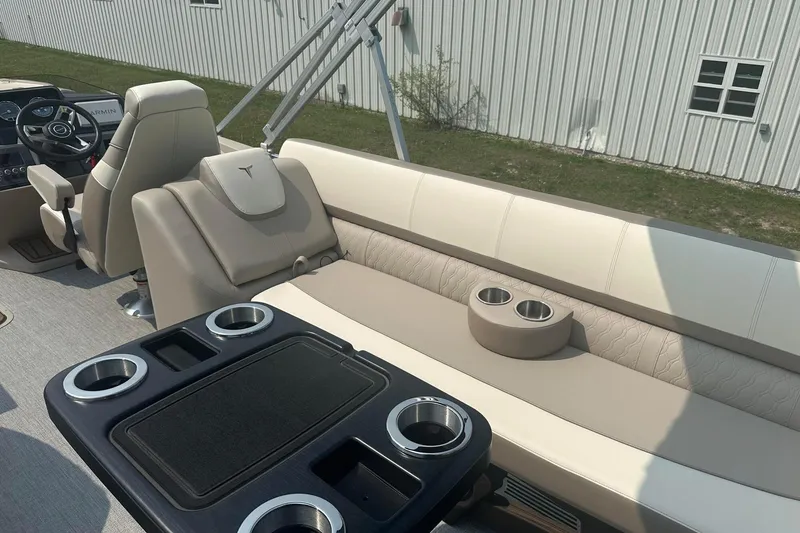 Slide: The Image of 2025 Tahoe 2585 boat interior with beige seating, cup holders, and steering console. - 26