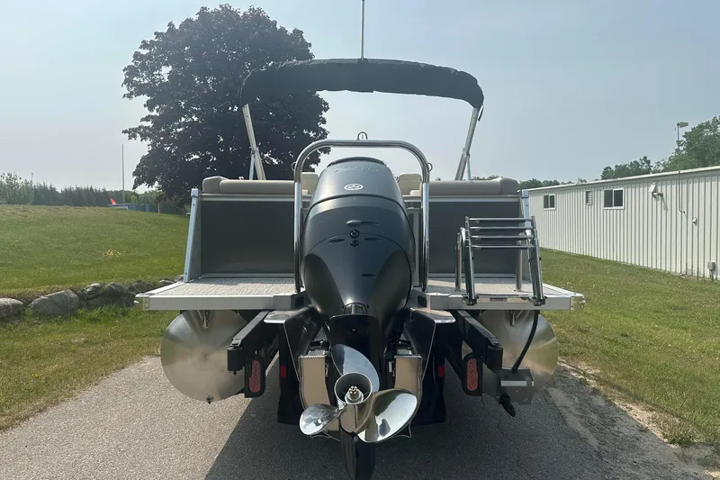 Slide: The Image of 2025 Tahoe 2585 pontoon boat rear view with outboard motor and ladder. - 4