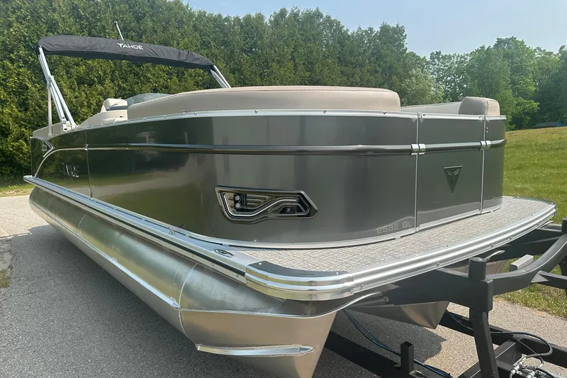 Slide: The Image of 2025 Tahoe 2585 pontoon boat on trailer, sleek design, parked outdoors. - 7