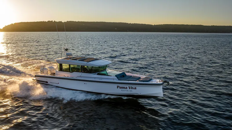 Slide: The Image of 2022 Axopar 37 XC cruising on open water at sunset. - 1