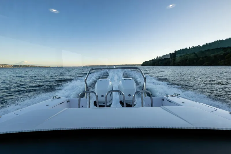 Slide: The Image of 2022 Axopar 37 XC cruising on a serene lake at sunset. - 15