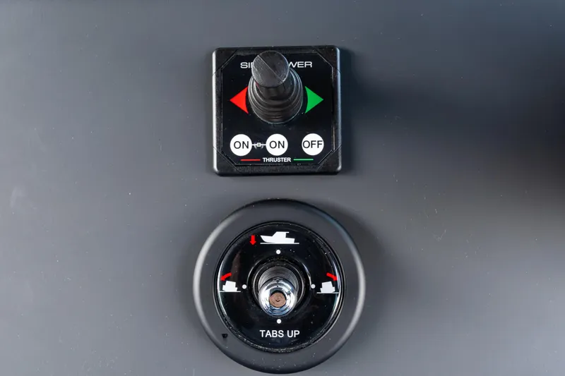 Slide: The Image of Axopar 37 XC 2022 boat controls, featuring thruster and trim tab switches. - 22
