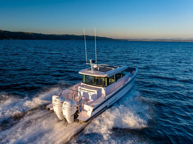 Slide: The Image of 2022 Axopar 37 XC cruising on open water at sunset. - 3