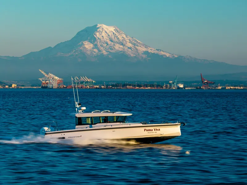 Slide: The Image of Axopar 37 XC 2022 boat cruising with mountain and port backdrop. - 4