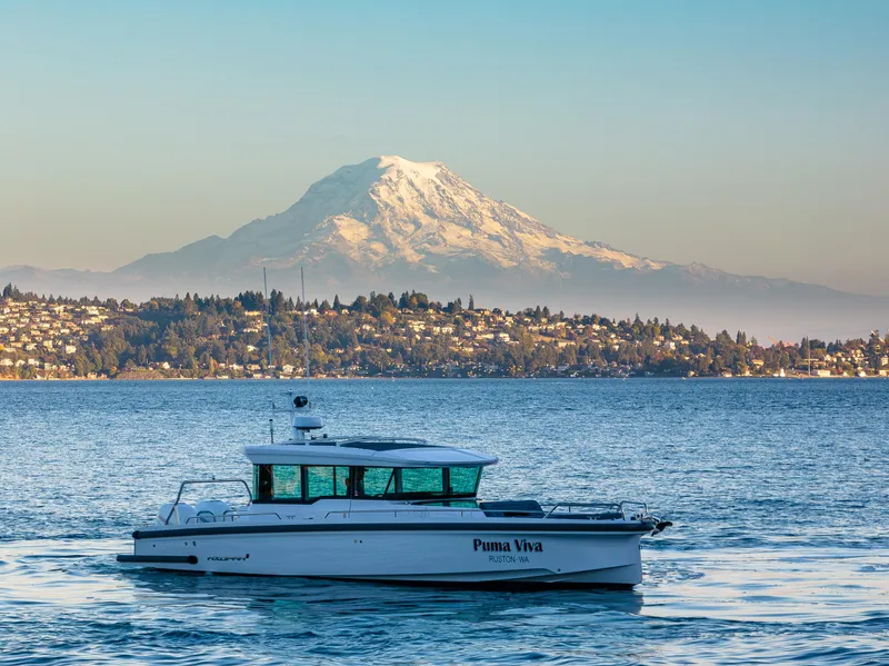 Slide: The Image of Axopar 37 XC 2022 boat on water with mountain backdrop. - 5