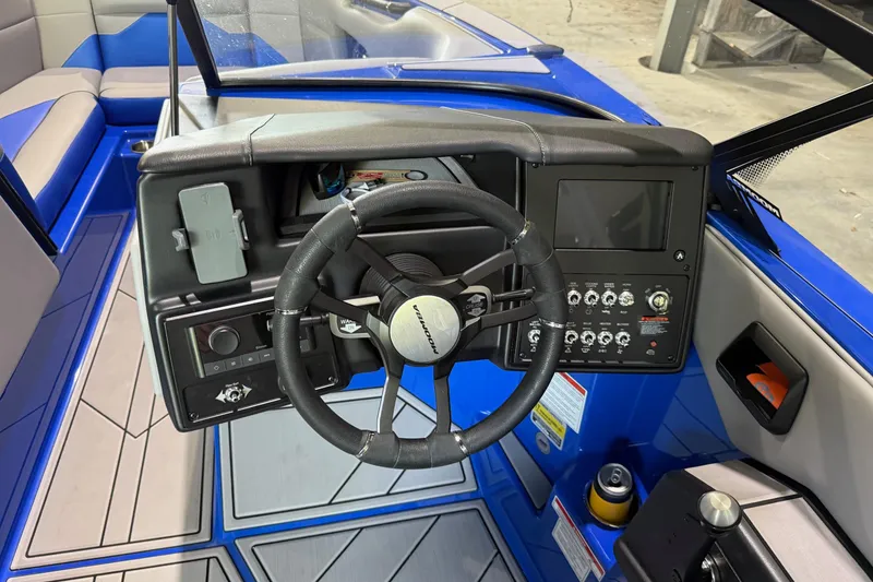 Slide: The Image of 2023 Moomba Mojo boat dashboard with steering wheel and control panel. - 5
