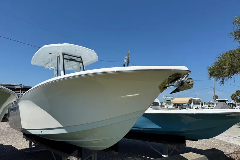 Slide: The Image of 2026 Tidewater 232 CC Adventure boat displayed outdoors under clear blue sky. - 21