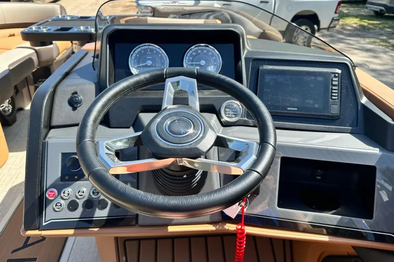 Slide: The Image of Steering wheel and dashboard of 2025 Tahoe 2585 boat with modern controls and displays. - 14