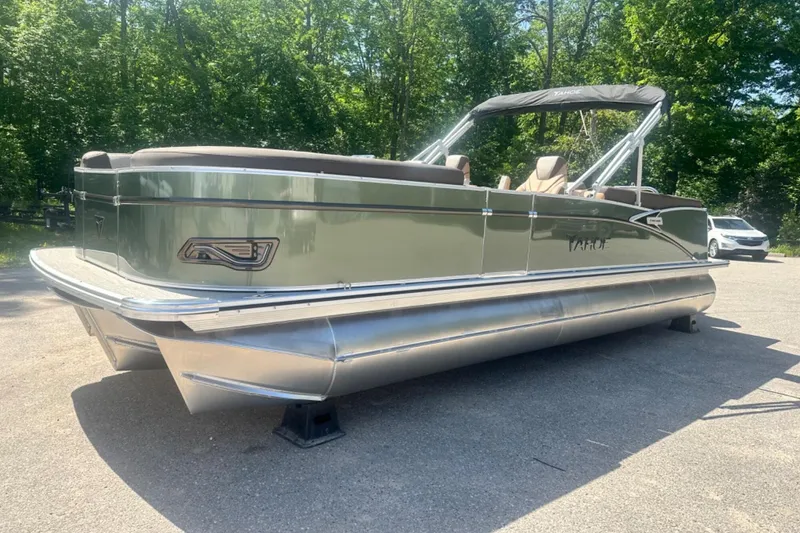 Slide: The Image of 2025 Tahoe 2585 pontoon boat on display in a sunny outdoor setting. - 2