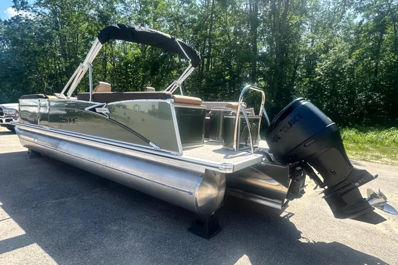 Slide: The Image of 2025 Tahoe 2585 pontoon boat with Suzuki outboard motor, parked outdoors. - 3