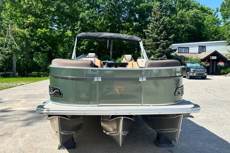 Slide: The Image of 2025 Tahoe 2585 pontoon boat on trailer, surrounded by lush greenery and a parked vehicle. - 8