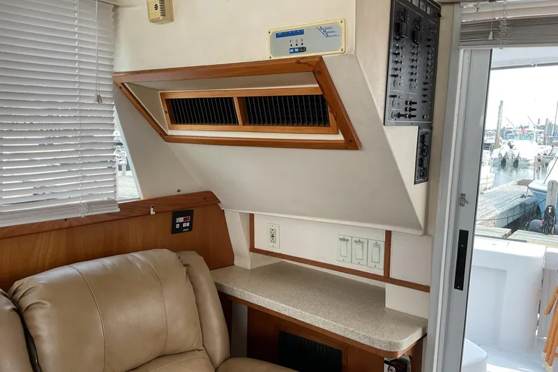 Slide: The Image of Interior of 1999 Mainship 350 Trawler with beige seating and control panel. - 12