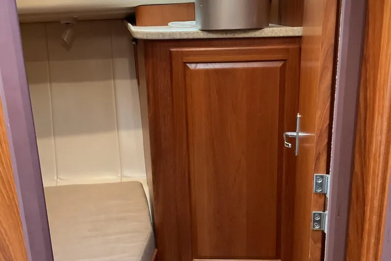 Slide: The Image of 1999 Mainship 350 Trawler interior with wooden cabinetry and a small seating area. - 16