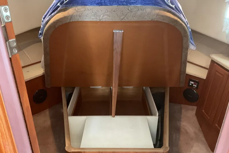 Slide: The Image of 1999 Mainship 350 Trawler interior with open storage compartments and wooden cabinetry. - 22