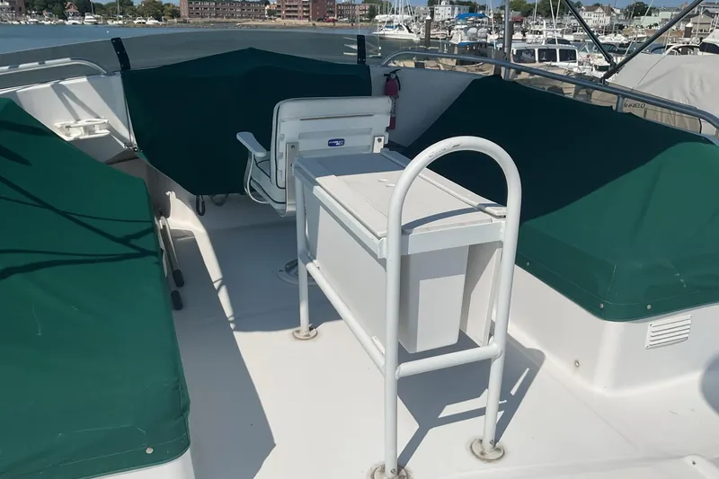 Slide: The Image of 1999 Mainship 350 Trawler deck with green covers and seating, docked at marina. - 5