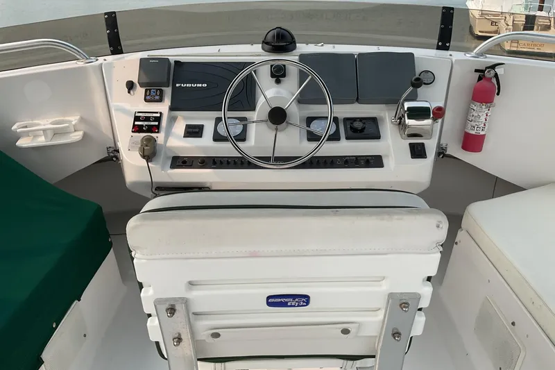 Slide: The Image of 1999 Mainship 350 Trawler helm with steering wheel, controls, and navigation equipment. - 7