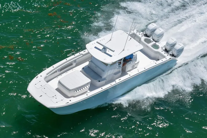 Slide: The Image of 2026 Invincible 40 Catamaran cruising on vibrant green water, showcasing sleek design and powerful engines. - 2