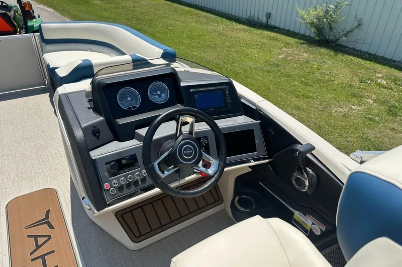 Slide: The Image of 2025 Tahoe 2585 boat dashboard with steering wheel, gauges, and control panel. - 14