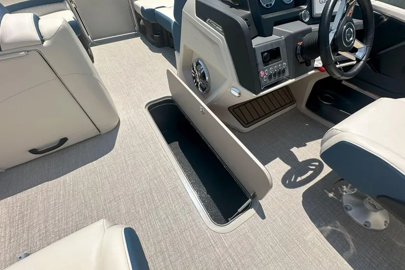 Slide: The Image of 2025 Tahoe 2585 boat interior with open storage compartment and modern dashboard. - 20