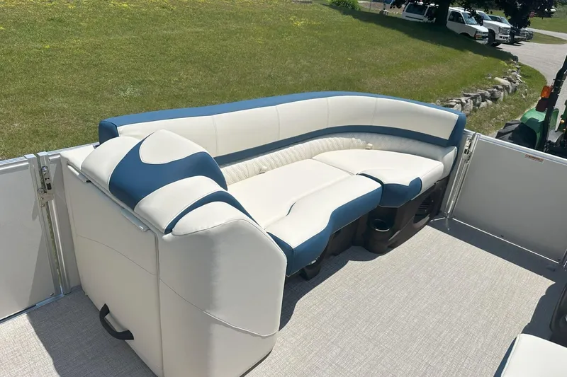 Slide: The Image of 2025 Tahoe 2585 boat interior with white and blue seating on a sunny day. - 24