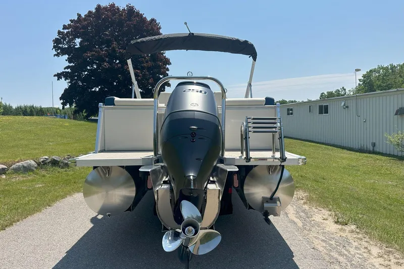 Slide: The Image of 2025 Tahoe 2585 boat with outboard motor, parked outdoors on a sunny day. - 5