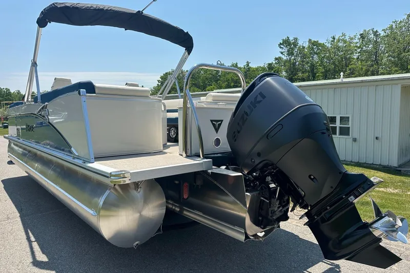 Slide: The Image of 2025 Tahoe 2585 pontoon boat with Suzuki outboard motor, parked outdoors. - 8