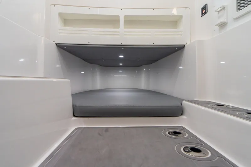 Slide: The Image of 2025 Invincible 43 Open Fisherman cabin interior with cushioned berth and storage compartments. - 11