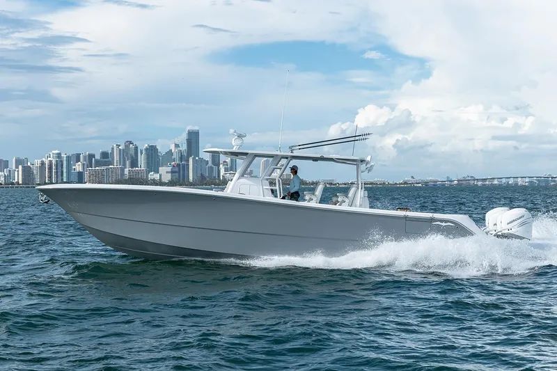 Slide: The Image of 2026 Invincible 46 Catamaran cruising on water with city skyline in background. - 2