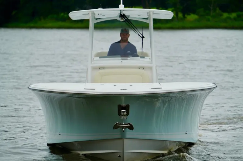 Slide: The Image of 2015 Southport 29 FE boat cruising on a calm lake with a person at the helm. - 18