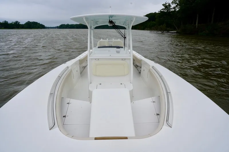 Slide: The Image of 2015 Southport 29 FE boat on calm water, showcasing spacious deck and seating. - 25