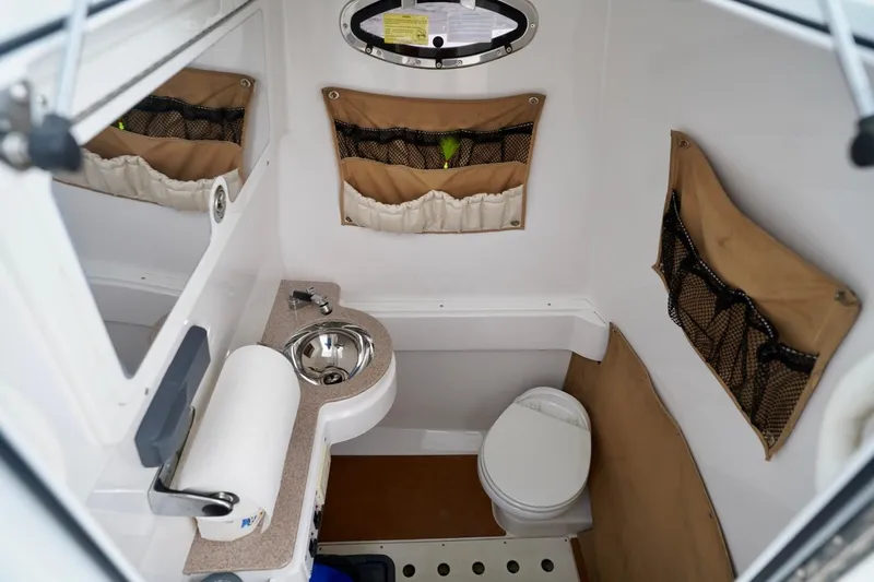Slide: The Image of 2015 Southport 29 FE boat interior with compact bathroom, sink, and storage pockets. - 35