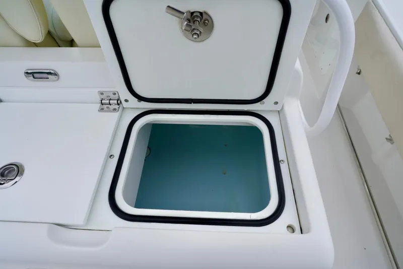 Slide: The Image of Open storage compartment on 2015 Southport 29 FE boat, featuring secure latch. - 44