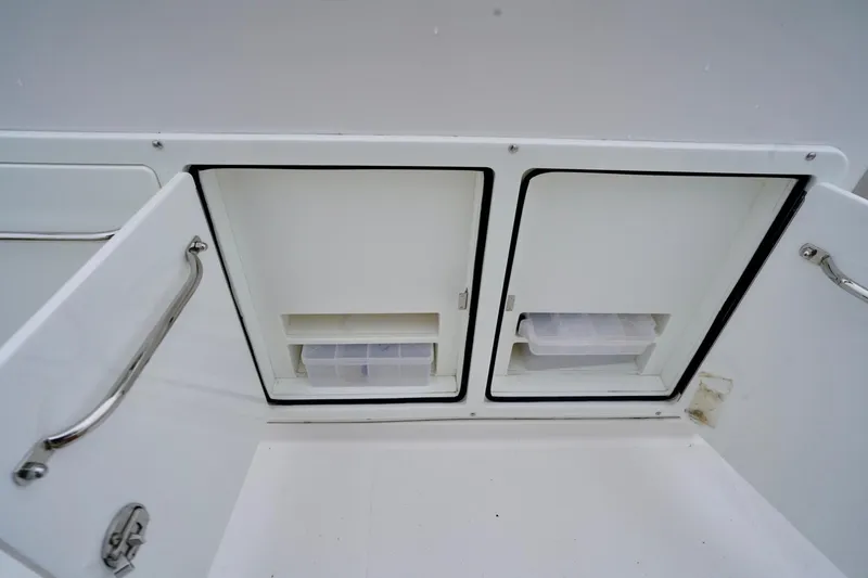 Slide: The Image of Storage compartments on a 2015 Southport 29 FE boat, featuring stainless steel handles. - 46