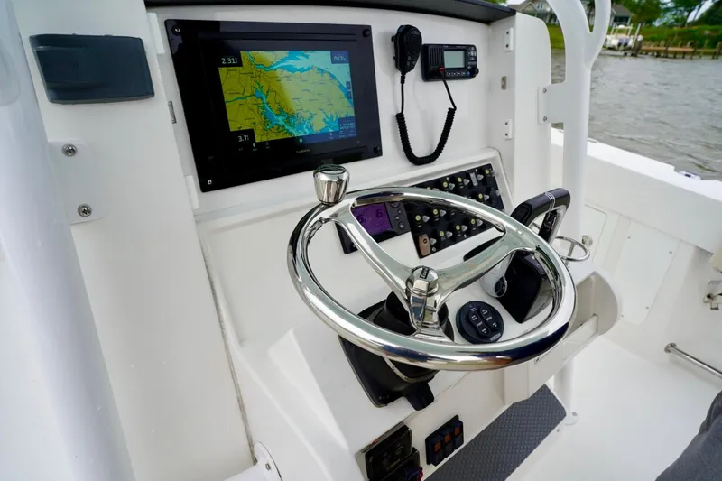 Slide: The Image of Control panel of a 2015 Southport 29 FE boat with navigation display and steering wheel. - 48