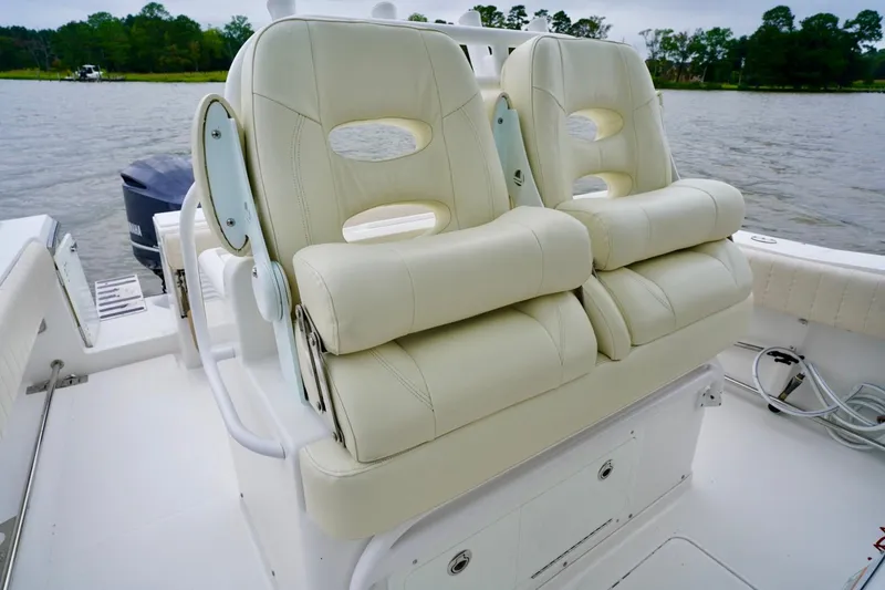 Slide: The Image of Luxurious seating on a 2015 Southport 29 FE boat, featuring plush white upholstery. - 53