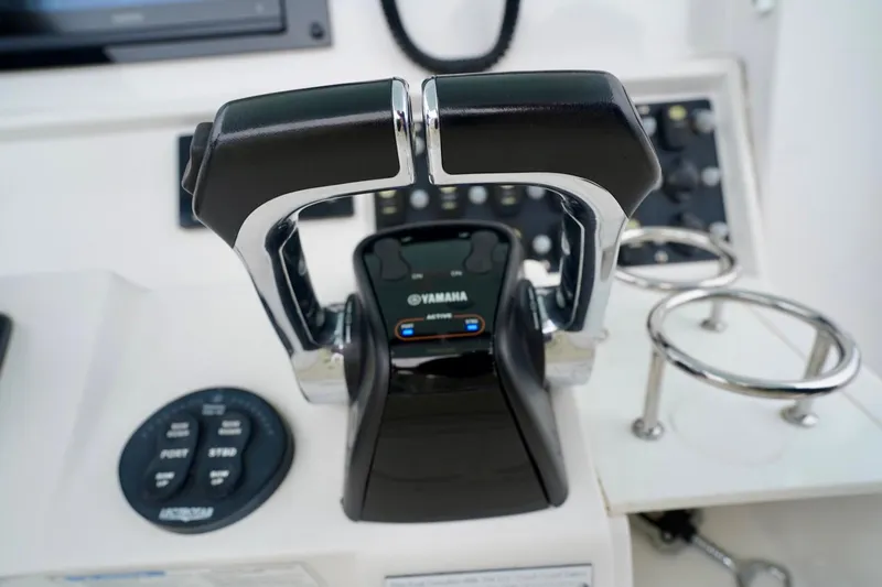 Slide: The Image of Control panel of a 2015 Southport 29 FE boat with Yamaha throttle levers. - 54