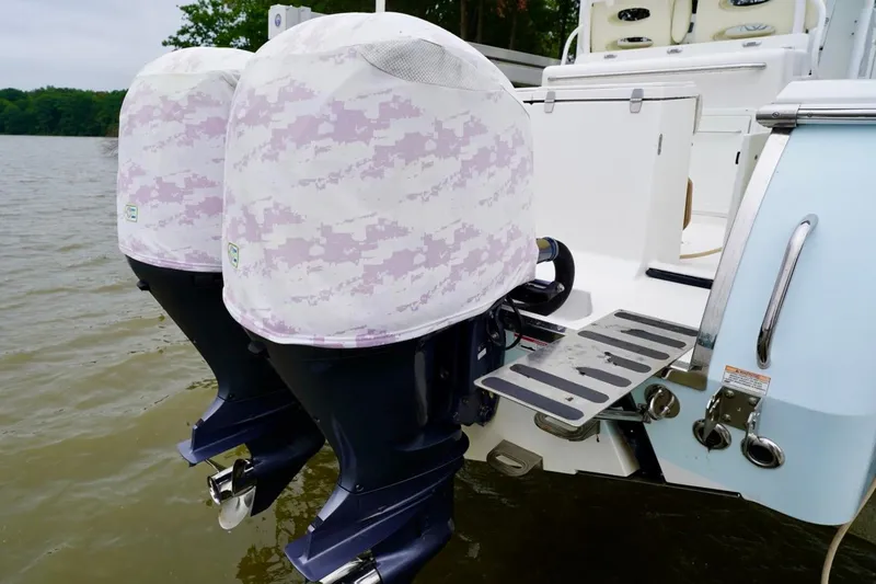 Slide: The Image of Twin outboard motors on a 2015 Southport 29 FE boat, covered with protective camo covers. - 57