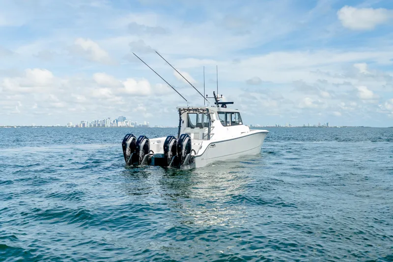 Slide: The Image of 2025 Invincible 46 Pilothouse boat on open water with city skyline in background. - 9